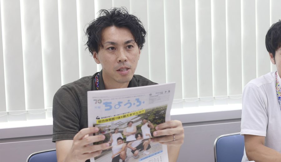 田澤さんが手に広報誌を持っている写真