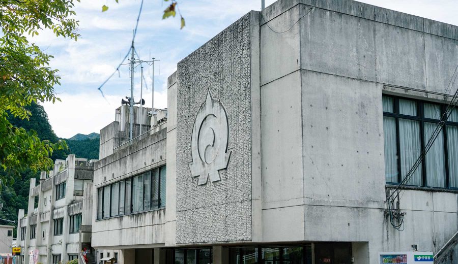 奥多摩町役場の庁舎。コンクリートの壁面に町章のレリーフが彫られている。