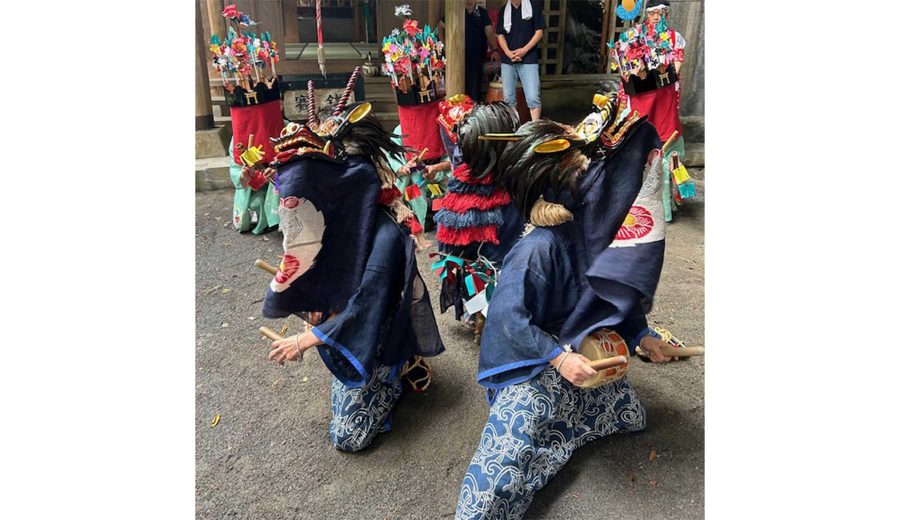 東京都奥多摩町の獅子舞の様子。獅子頭を被りお腹に太鼓をつけた獅子役が3人炎になって踊っている。奥には頭に花飾りと顔を隠すような赤い布を着けた「ささらすり」役が竹筒のような道具を打ち鳴らしている。