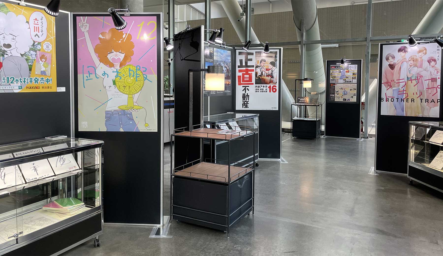 立川ロケーションサービス presents ロケ地の街 立川展 2026 会場内の様子。撮影時の様子を紹介するパネルや漫画作品のコミック表紙、出演者サインなどが並んでいる
