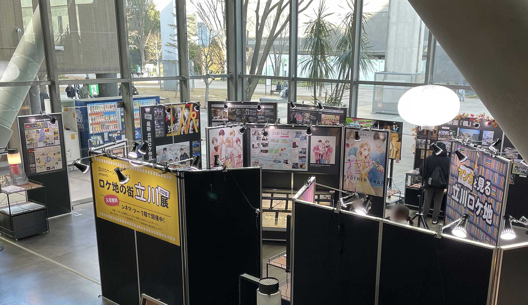 立川ロケーションサービス presents ロケ地の街 立川展 2026 会場内の様子。撮影時の様子を紹介するパネルや漫画作品のコミック表紙、出演者サインなどが並んでいる